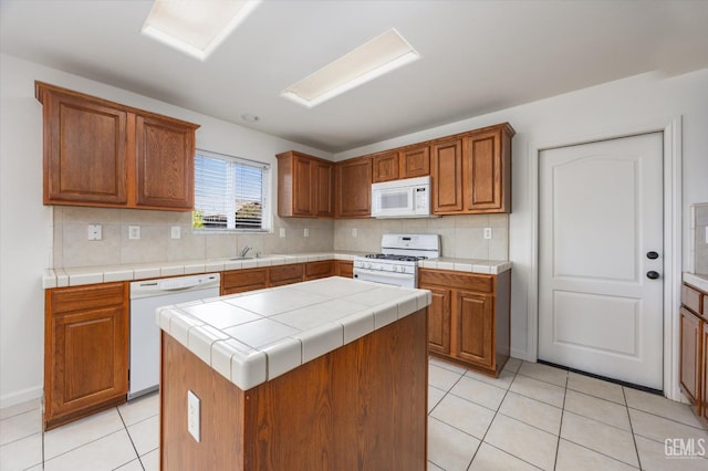 11018 Sonoma Creek Ct, Bakersfield, CA 93312 - kitchen with white appliances, light tile patterned floors, a kitchen island, and tasteful backsplash