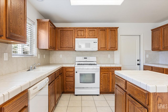 11018 Sonoma Creek Ct, Bakersfield, CA 93312 - kitchen with white appliances, a sink, tile countertops, backsplash, and brown cabinets