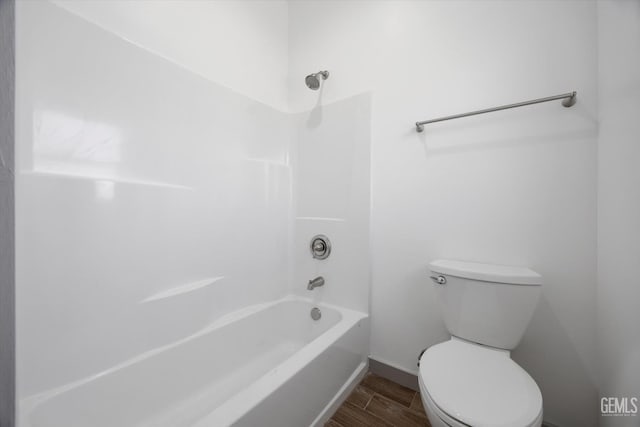 329 F St, Bakersfield, CA 93304 - full bathroom featuring wood finished floors, toilet, bathing tub / shower combination, and baseboards