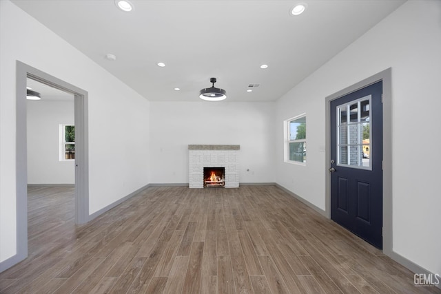 329 F St, Bakersfield, CA 93304 - unfurnished living room featuring wood finished floors, recessed lighting, a warm lit fireplace, and baseboards