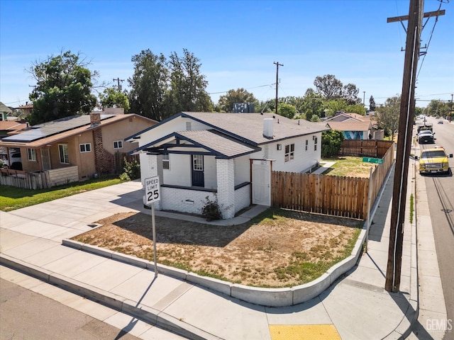 329 F St, Bakersfield, CA 93304 - view of front of house with brick siding, fence, a residential view, and concrete driveway