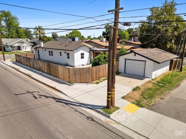 329 F St, Bakersfield, CA 93304 - view of front facade featuring fence, concrete driveway, an outbuilding, and a residential view