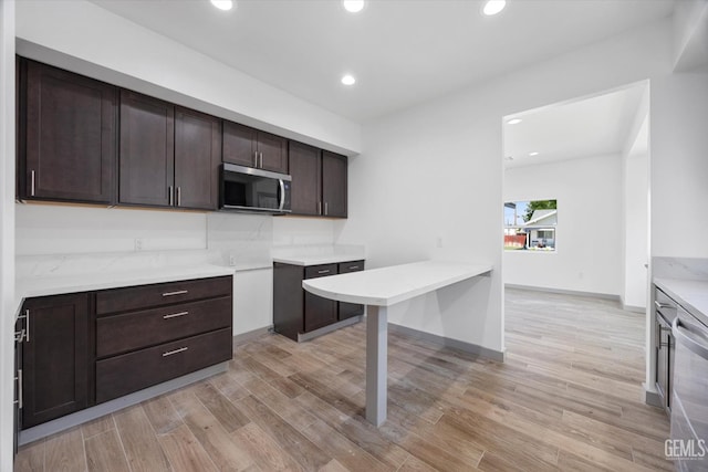 329 F St, Bakersfield, CA 93304 - kitchen with stainless steel appliances, dark brown cabinets, light wood finished floors, light countertops, and recessed lighting