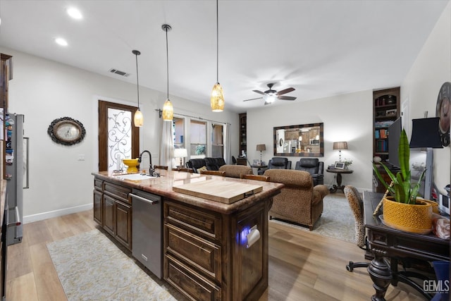 9200 Bridget Leigh Way, Bakersfield, CA 93312 - kitchen with stainless steel dishwasher, dark brown cabinetry, an island with sink, light wood-type flooring, and ceiling fan