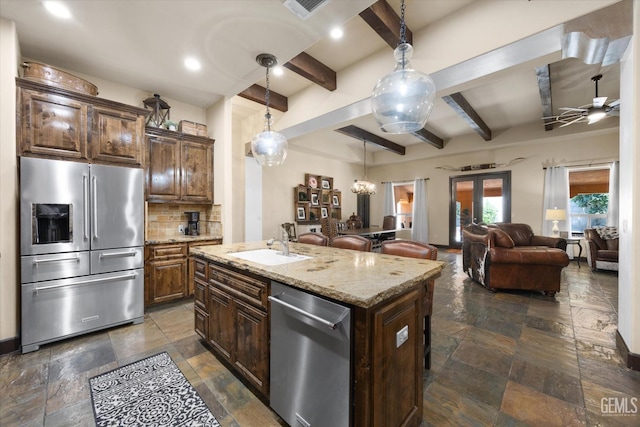 9200 Bridget Leigh Way, Bakersfield, CA 93312 - kitchen featuring appliances with stainless steel finishes, stone tile floors, beam ceiling, decorative backsplash, and light stone countertops