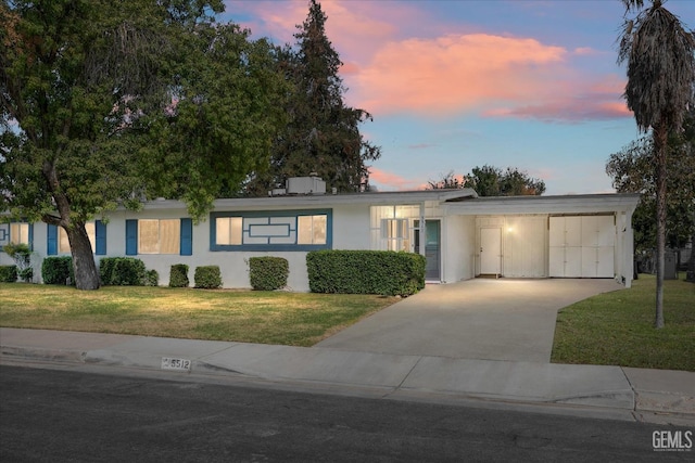 ranch-style home featuring a yard and a carport