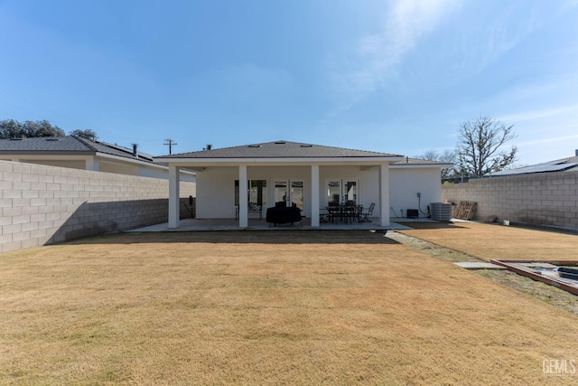 rear view of house with cooling unit, a yard, and a patio