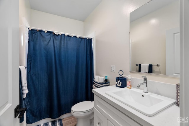 bathroom featuring vanity, wood-type flooring, and toilet