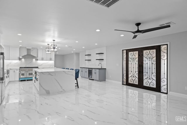 foyer with beverage cooler, recessed lighting, a chandelier, light marble finish flooring, and french doors