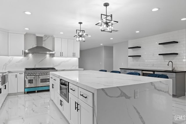 kitchen featuring wall chimney range hood, double oven range, open shelves, a kitchen island, and recessed lighting
