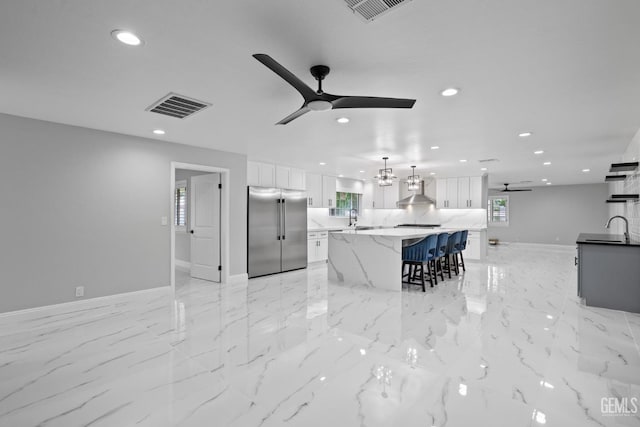 kitchen featuring stainless steel appliances, ceiling fan, baseboards, white cabinetry, and a sink