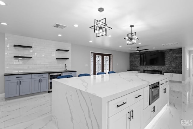 kitchen with open shelves, wine cooler, ceiling fan, recessed lighting, and hanging light fixtures