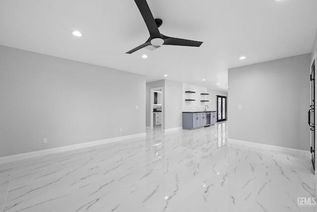 unfurnished living room featuring recessed lighting, light marble finish flooring, ceiling fan, baseboards, and a sink