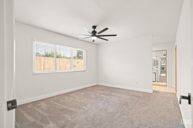 carpeted empty room featuring a ceiling fan and baseboards