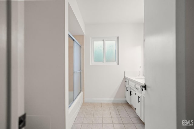 full bath with baseboards, vanity, tile patterned flooring, and shower / bath combination with glass door