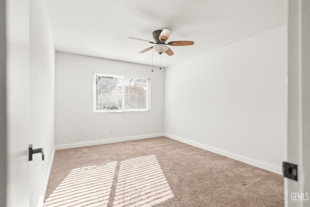 carpeted empty room featuring a ceiling fan and baseboards