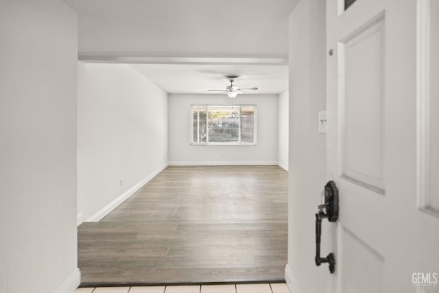 spare room with baseboards, a ceiling fan, and wood finished floors