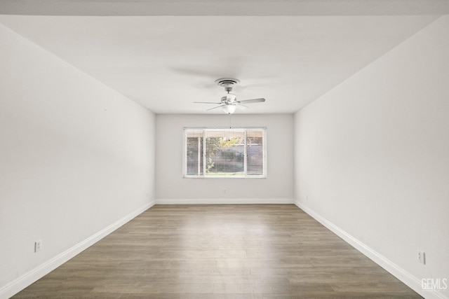 empty room with wood finished floors, baseboards, and ceiling fan