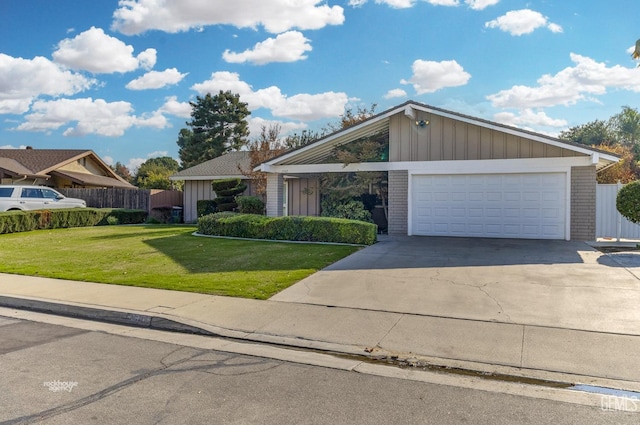 view of front facade featuring fence, a front lawn, concrete driveway, board and batten siding, and a garage