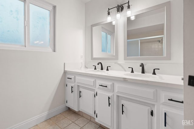 bathroom featuring double vanity, tile patterned floors, baseboards, and a sink