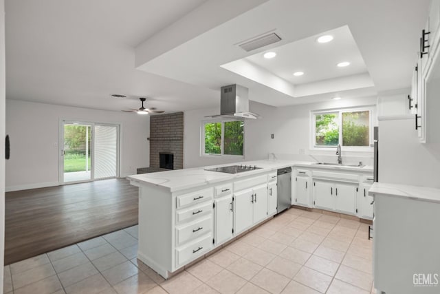 kitchen featuring black electric cooktop, visible vents, stainless steel dishwasher, wall chimney exhaust hood, and a peninsula