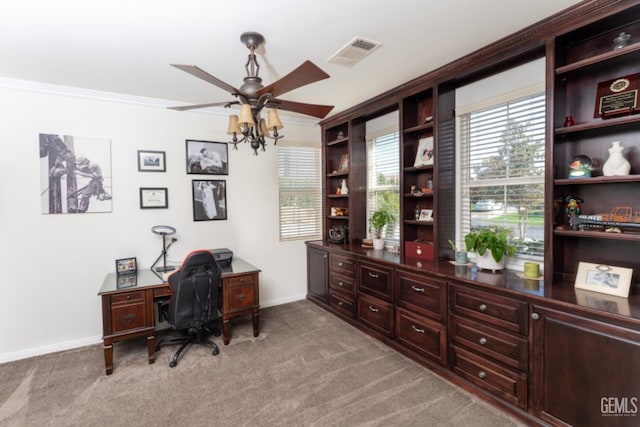 carpeted office space with baseboards, a ceiling fan, visible vents, and crown molding