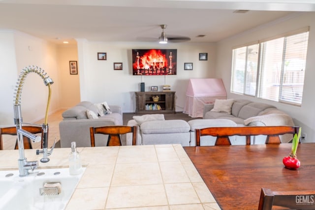 living room featuring ornamental molding and a ceiling fan