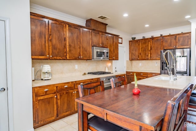 kitchen featuring visible vents, backsplash, appliances with stainless steel finishes, ornamental molding, and light tile patterned flooring