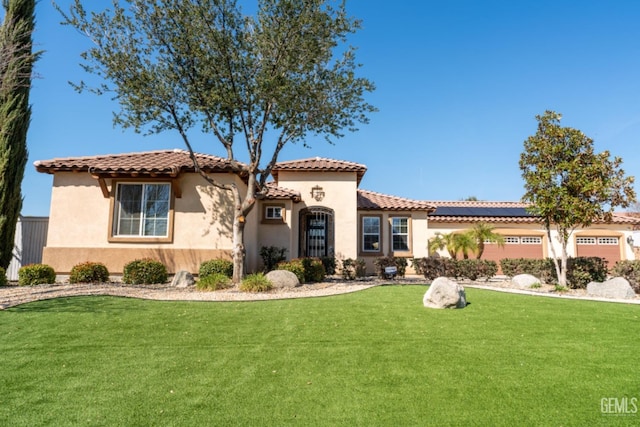 mediterranean / spanish-style home with a tiled roof, a front lawn, and stucco siding