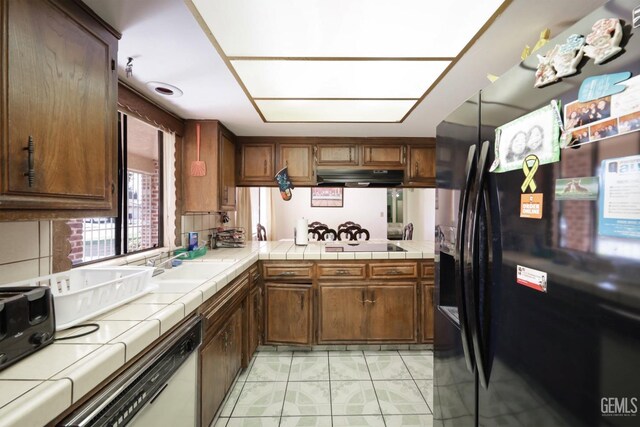 5116 Sherman Ave, Bakersfield, CA 93309 - kitchen with sink, tile countertops, tasteful backsplash, and black appliances