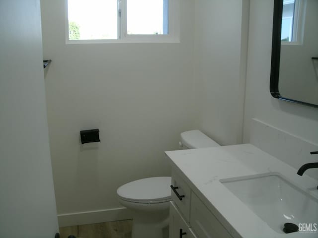 3111 Bucknell St, Bakersfield, CA 93305 - bathroom with toilet, vanity, wood finished floors, and baseboards