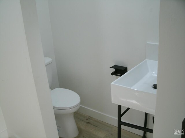 3111 Bucknell St, Bakersfield, CA 93305 - bathroom featuring toilet, baseboards, and wood finished floors