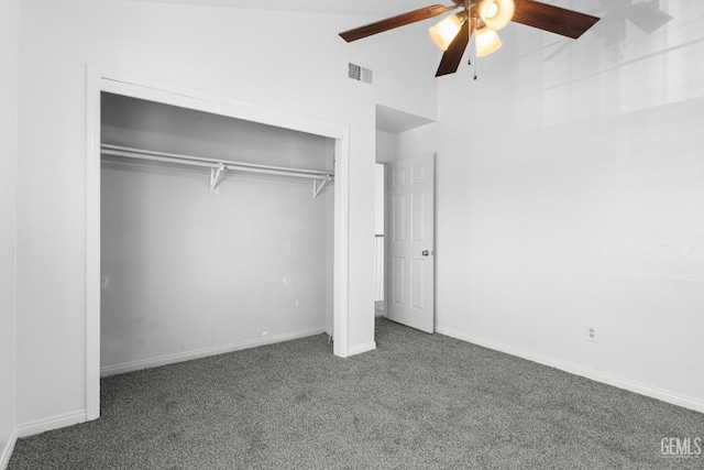 unfurnished bedroom featuring ceiling fan, dark carpet, lofted ceiling, and a closet