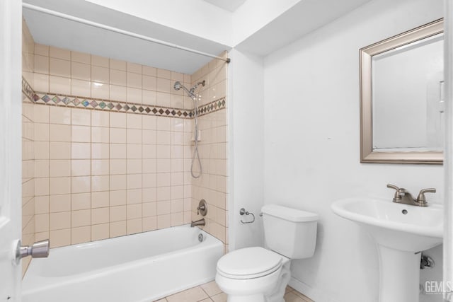 full bathroom with tile patterned floors, tiled shower / bath combo, toilet, and sink