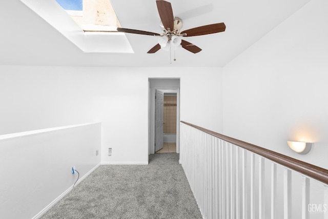 hallway featuring light carpet and a skylight