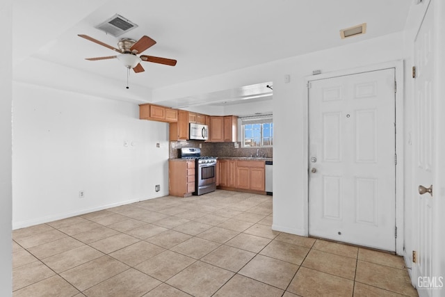 kitchen featuring ceiling fan, decorative backsplash, light tile patterned floors, and stainless steel appliances