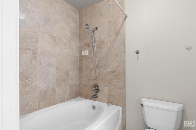 bathroom featuring tiled shower / bath combo and toilet