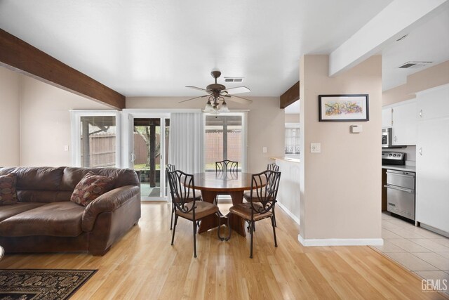 dining area featuring light wood-type flooring, visible vents, and beamed ceiling