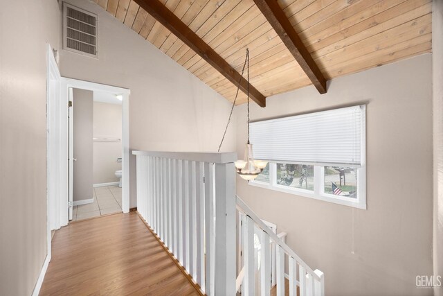 hallway with visible vents, wood ceiling, vaulted ceiling with beams, an upstairs landing, and a chandelier