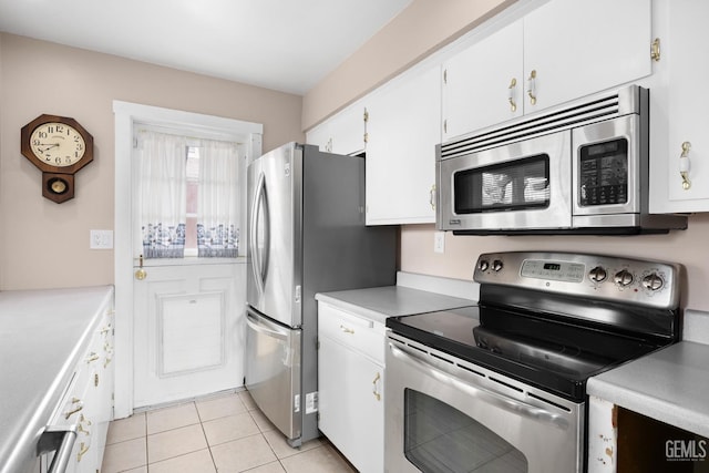 kitchen featuring stainless steel appliances, light tile patterned flooring, light countertops, and white cabinets