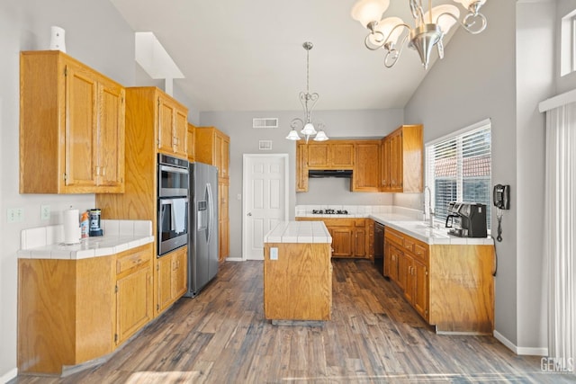 kitchen with a notable chandelier, black appliances, a sink, a center island, and tile counters