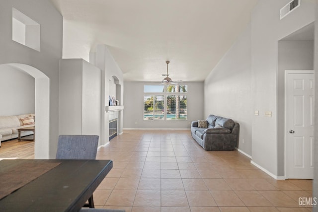 dining room featuring visible vents, baseboards, ceiling fan, light tile patterned floors, and a fireplace