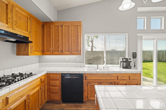 kitchen featuring under cabinet range hood, lofted ceiling, brown cabinets, black appliances, and a sink