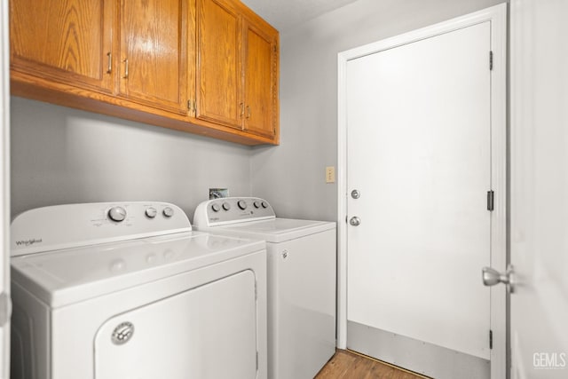 laundry room featuring separate washer and dryer and cabinet space