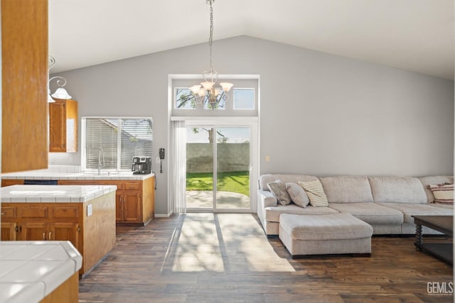 living area with a notable chandelier, dark wood-style floors, and high vaulted ceiling