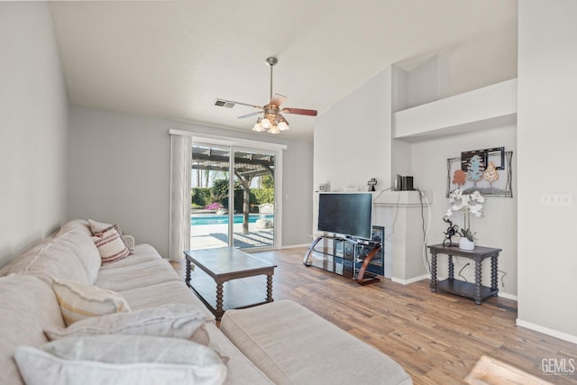 living area with ceiling fan, visible vents, baseboards, and wood finished floors