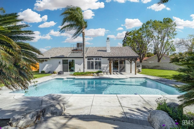 pool featuring a pergola, fence, a patio area, and a lawn