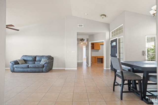 dining area with light tile patterned floors, a ceiling fan, baseboards, visible vents, and high vaulted ceiling