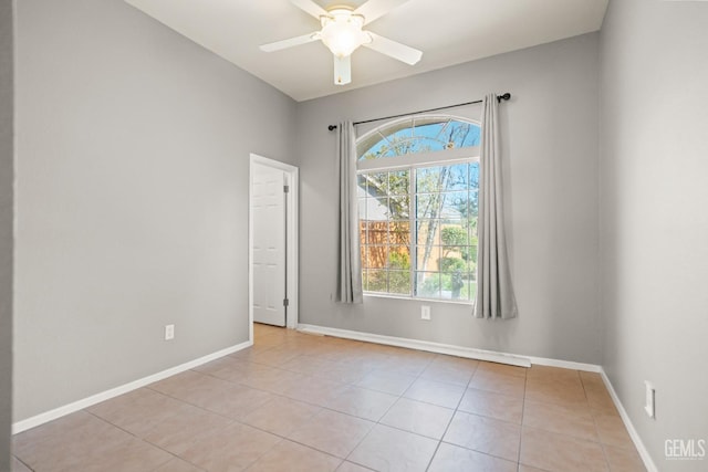 empty room with baseboards, ceiling fan, and light tile patterned flooring