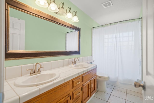 bathroom with a sink, visible vents, toilet, and tile patterned flooring